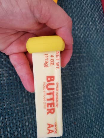 a reviewer photo of a food hugger on a stick of butter