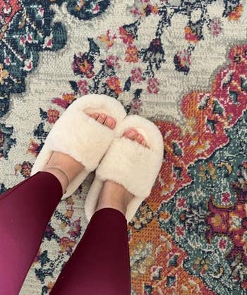 a different reviewer wearing fluffy white slippers and leggings standing on an ornate rug