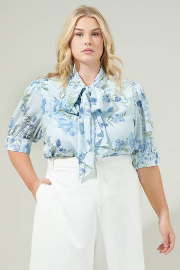 Model in a blue floral bow blouse with short sleeves