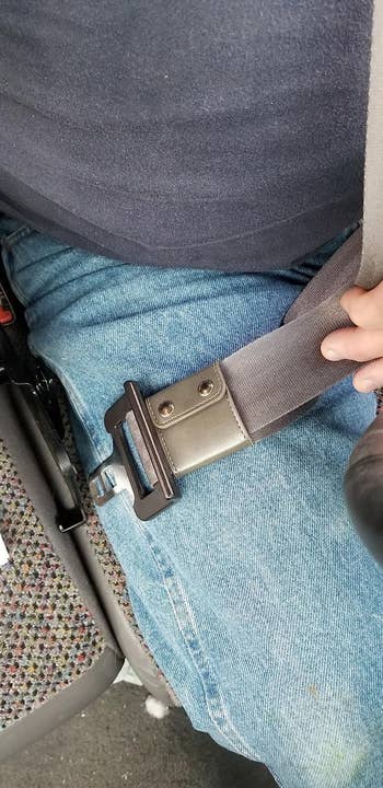 reviewer photo of the clip positioned near the seat belt buckle