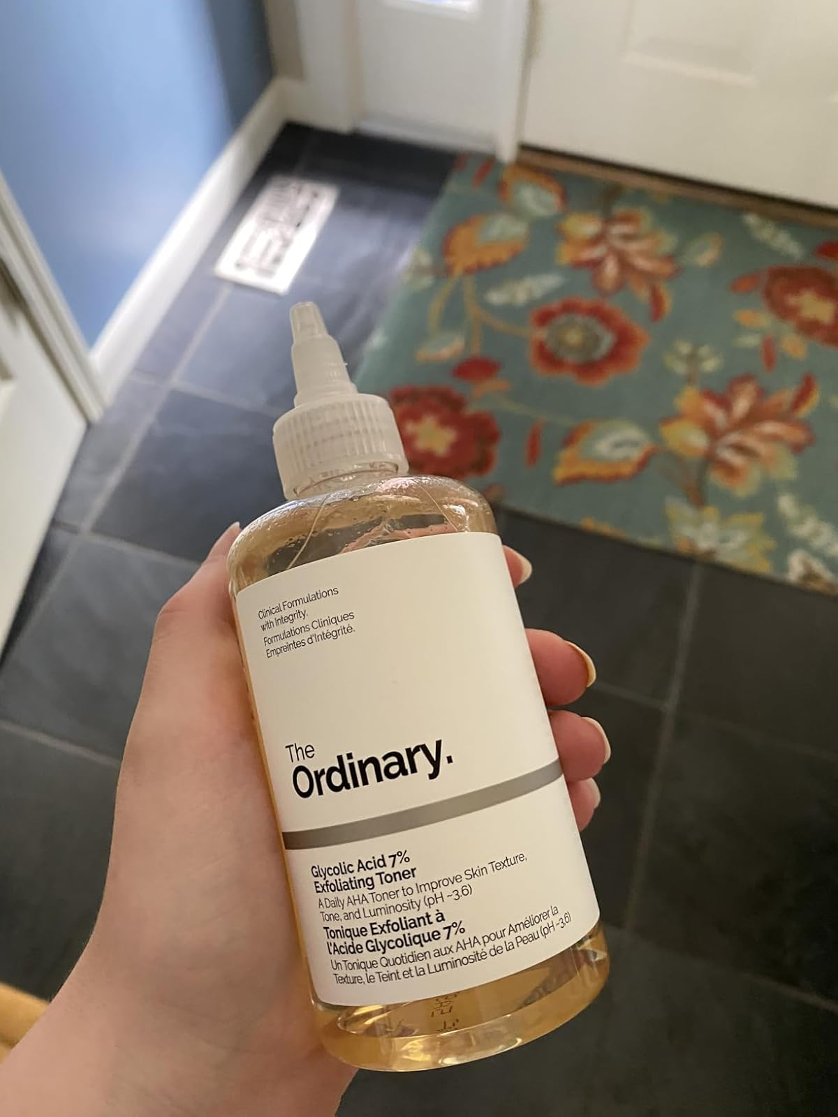A manus  holding a vessel  of The Ordinary Glycolic Acid 7% Toning Solution, a fashionable  skincare merchandise  for exfoliating and toning the skin
