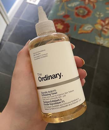 A manus holding a vessel of The Ordinary Glycolic Acid 7% Toning Solution, a fashionable skincare merchandise for exfoliating and toning the skin