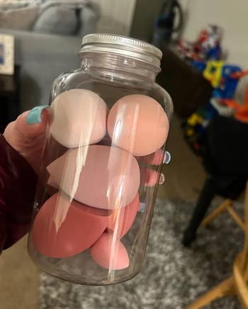 reviewer hoplding jar of pink sponge blenders
