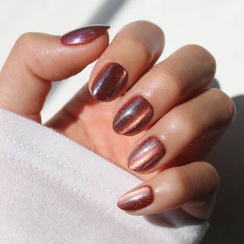 Close-up of a manus  with metallic, glossy nails showcasing a stylish manicure, cleanable   for a fashion-forward buying  look