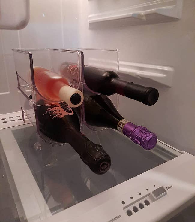 reviewer image of four bottles of wine in two wine holders in a fridge