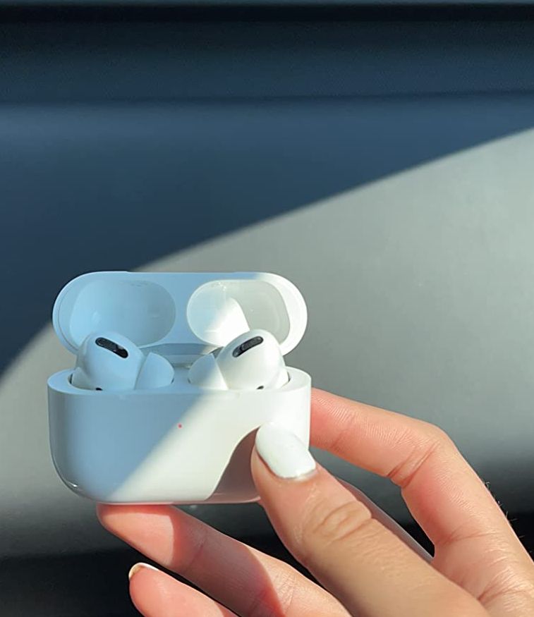 reviewer holding up the airpods in their case