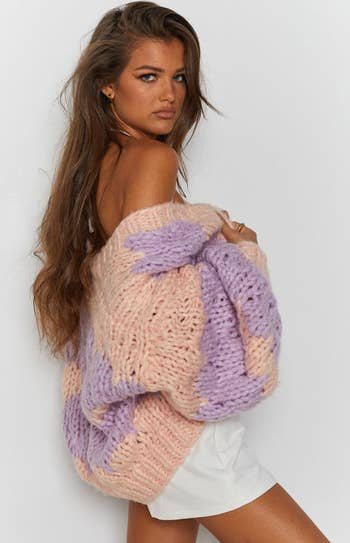 model wearing light pink and purple cardigan draped over their shoulders