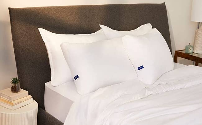 a bed with two casper pillows on it 
