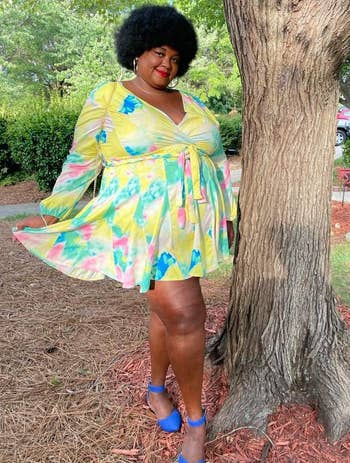 reviewer wearing the yellow pastel print dress