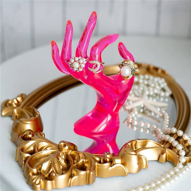 neon pink mannequin hand used as jewelry holder