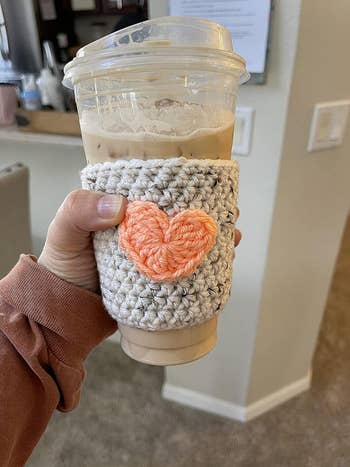 a knit coozy with a pink heart in the middle