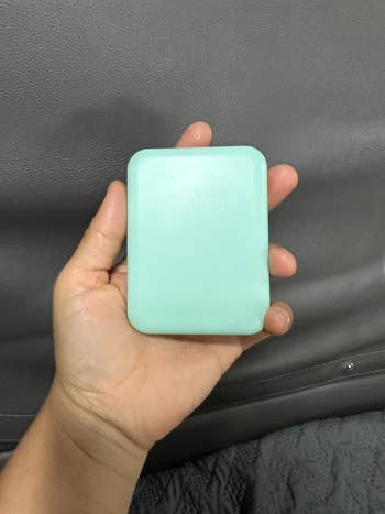 reviewer holding a closed compact mirror