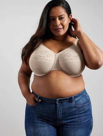 Person models a stylish, supportive bra and jeans, showcasing comfortable, mundane wear