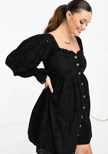 model posing in black square neck button down mini dress