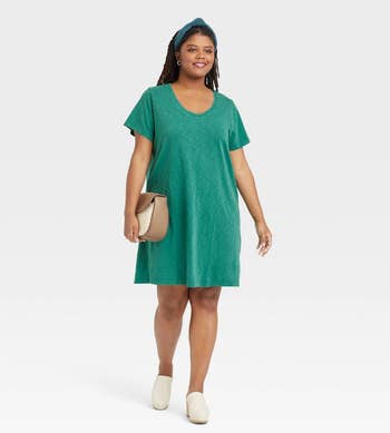 model in green scoop neck above the knee dress