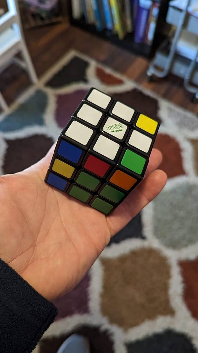 reviewer holding up a rubik's cube that hasn't been solved yet