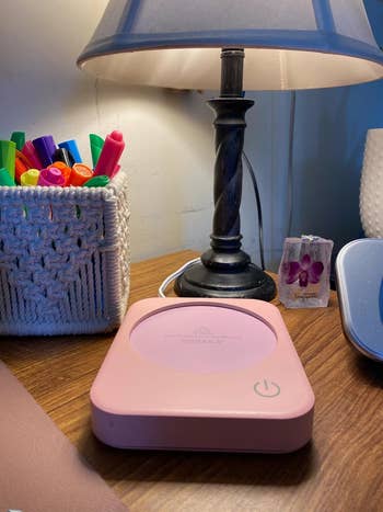 the pink coffee warmer on a nightstand