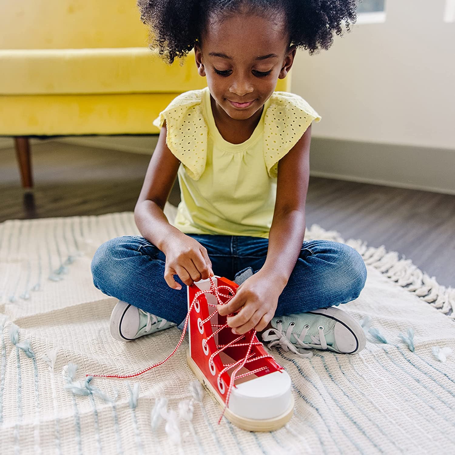 kid model tying shoes on the big red shoe learning toy