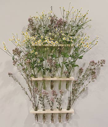 reviewer's three tiered hanging prop vase wall decor filled with wild flowers 