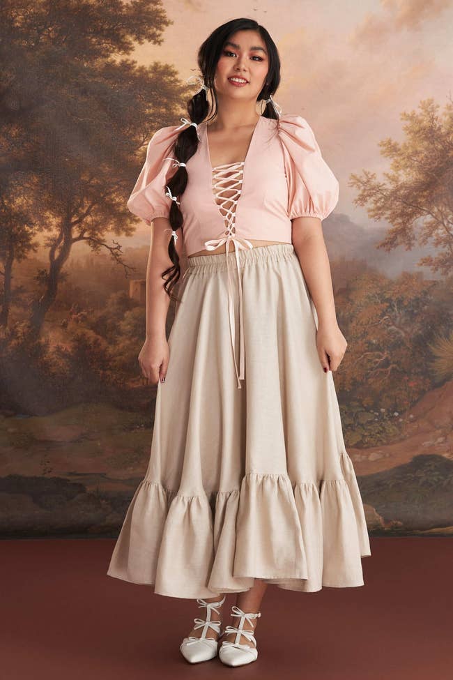 model in the beige linen skirt with a pink puff sleeve top