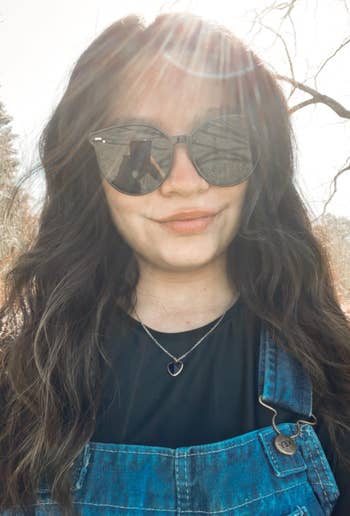 reviewer wearing shiny black frame sunglasses