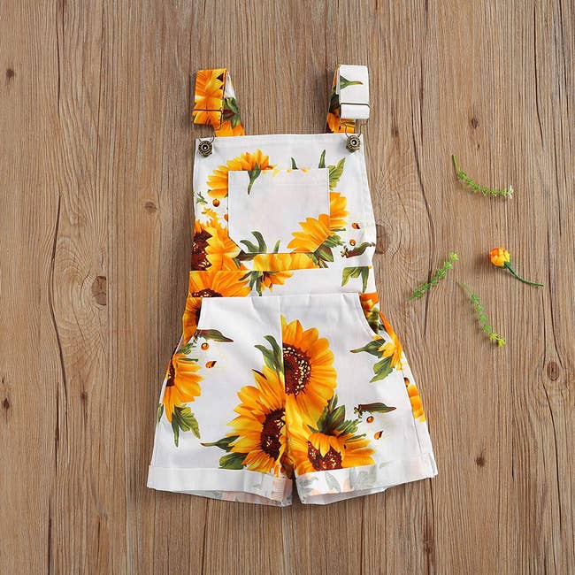 white children's overalls with yellow sunflowers on them