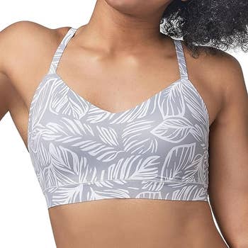A model is wearing a printed sports bra with a leaf design pattern