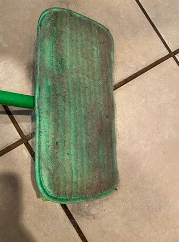 same reviewer's reusable green mop pad covered in dog hair it picked up