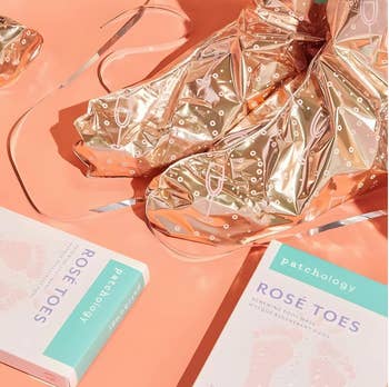 Shiny foil ft  masks and Patchology Rosé Toes packaging displayed connected  a surface