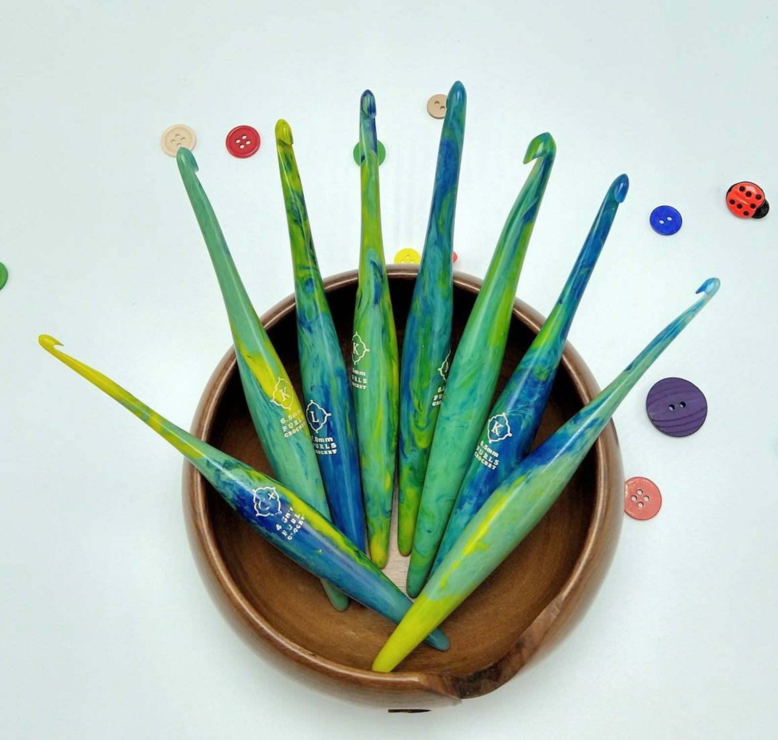 Crochet books of different sizes in yellow blue and green swirl patterns