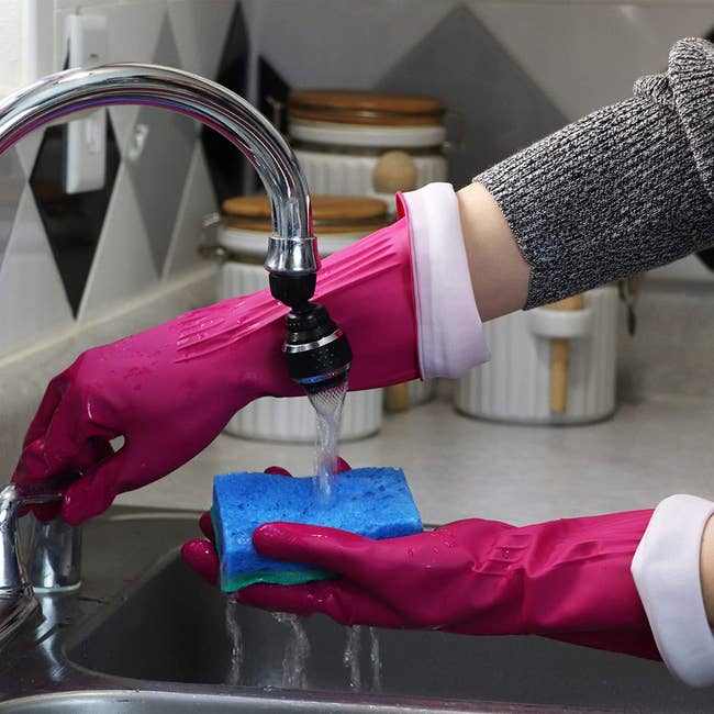 person wearing gloves while washing dishes