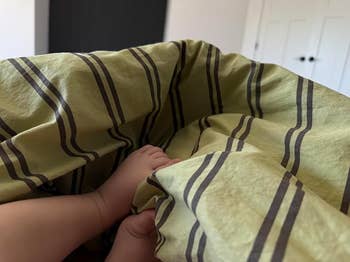 Baby's feet peek from nether striped bedding. Cozy and serene setting