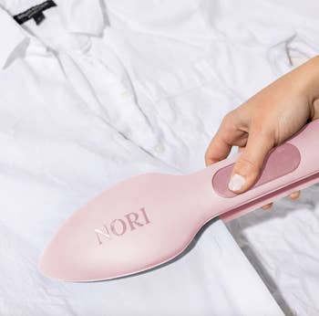a model using the nori press to iron a button down shirt