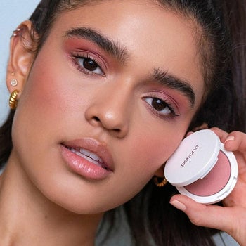 model wearing and holding the blush