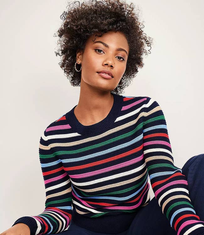 model in navy and pink white cream green light blue and red stripe crewneck sweater