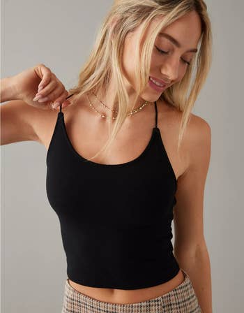 a model in a black tank top with thin straps