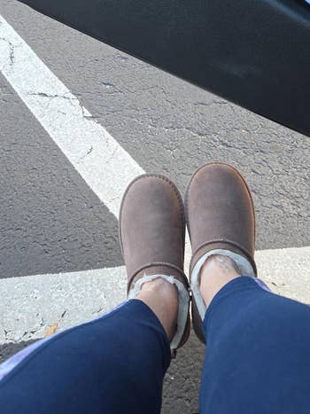 Person wearing cozy, fleece-lined slippers, sitting successful  a car   with the doorway  open. Asphalt parking batch  disposable   beneath. Casual and comfy  footwear
