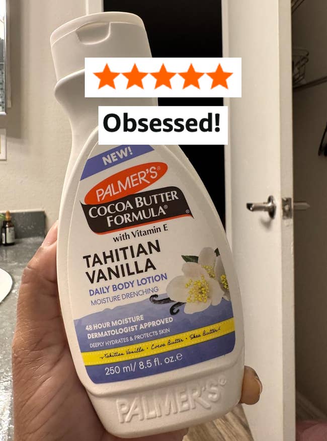 A manus holds a vessel of Palmer's Tahitian Vanilla Body Lotion, labeled