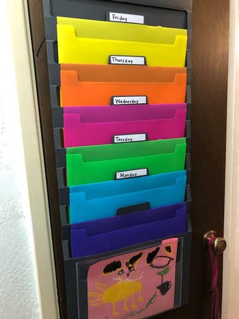 Reviewer's folding wall organizer labeled with the days of the week on their door