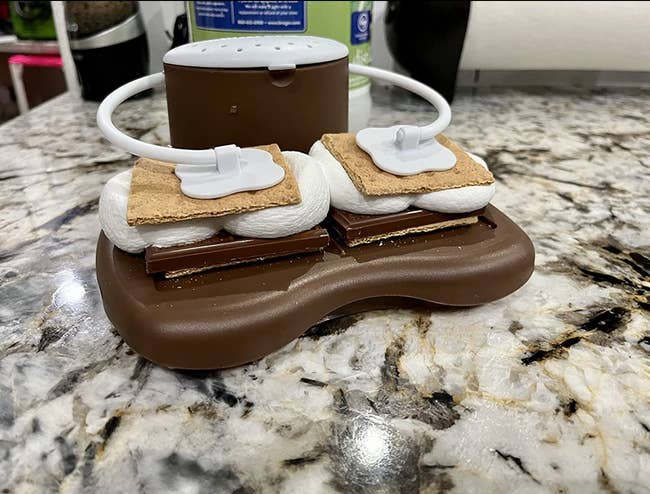 The s'mores maker holding two s'mores