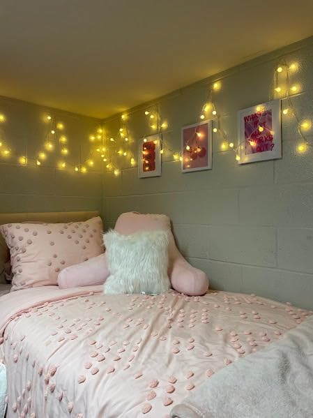 Cozy chamber  setup with decorative pillows, a plush chair, and drawstring  lights connected  the wall, creating a warm, inviting atmosphere