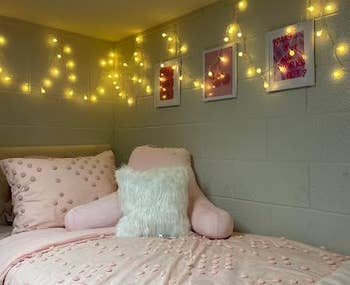 Cozy chamber setup with decorative pillows, a plush chair, and drawstring lights connected the wall, creating a warm, inviting atmosphere