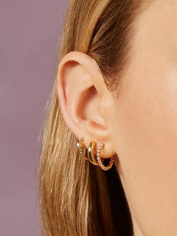 model wearing all three earring in their ear