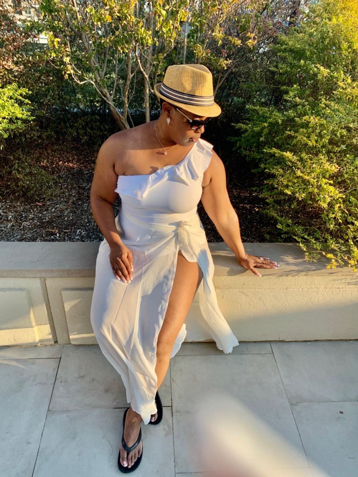 reviewer wearing the white bathing suit with a white skirt and hat 