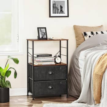 lifestyle photo of nightstand with tall platform next to bed