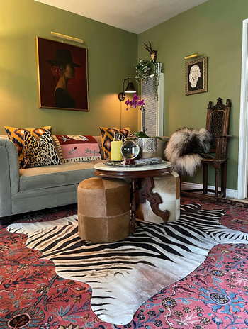 faux hide rug over turkish rug in reviewer's maximalist living room