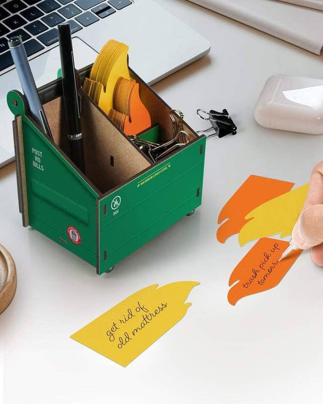 cardboard pencil cup shaped like a dumpster with sticky notes shaped like flames