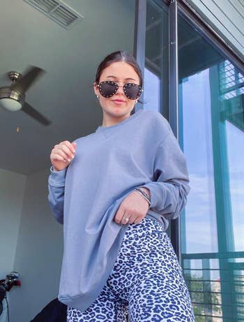 reviewer wearing the white leopard print bike shorts with an oversized gray sweatshirt