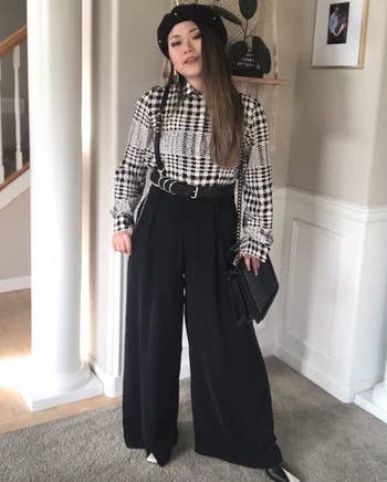 reviewer wearing the black pants with a black and white top
