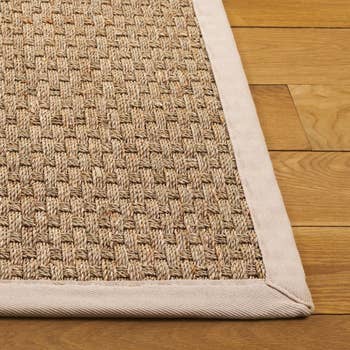 Close-up of a woven jute rug with a creaseless borderline lying connected a woody floor, highlighting its earthy texture for a location decor article